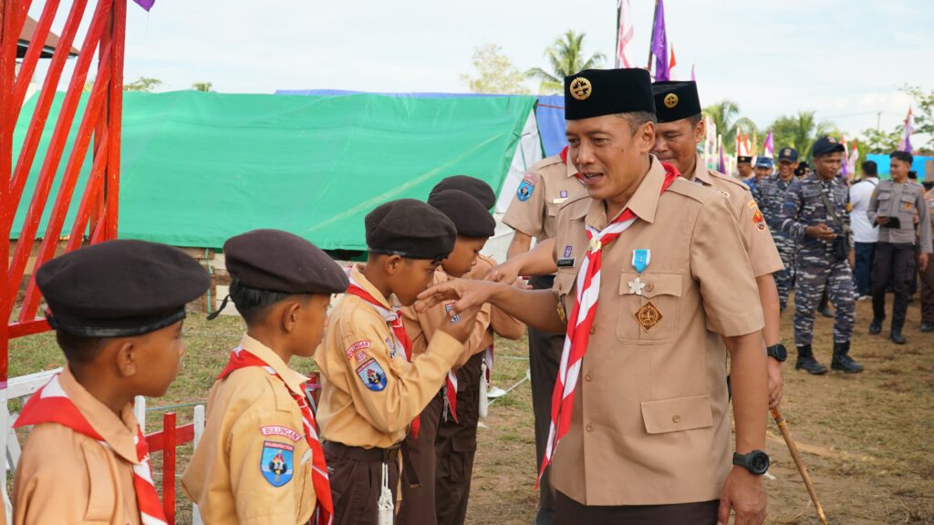 HARI PRAMUKA: Sekretaris Dearah Kabupaten Bulungan Risdianto, S.Pi.M.Si saat menyalami anak-anak pramuka di Desa karang Agung, Tanjung Palas Utara, Rabu (14/8/24).