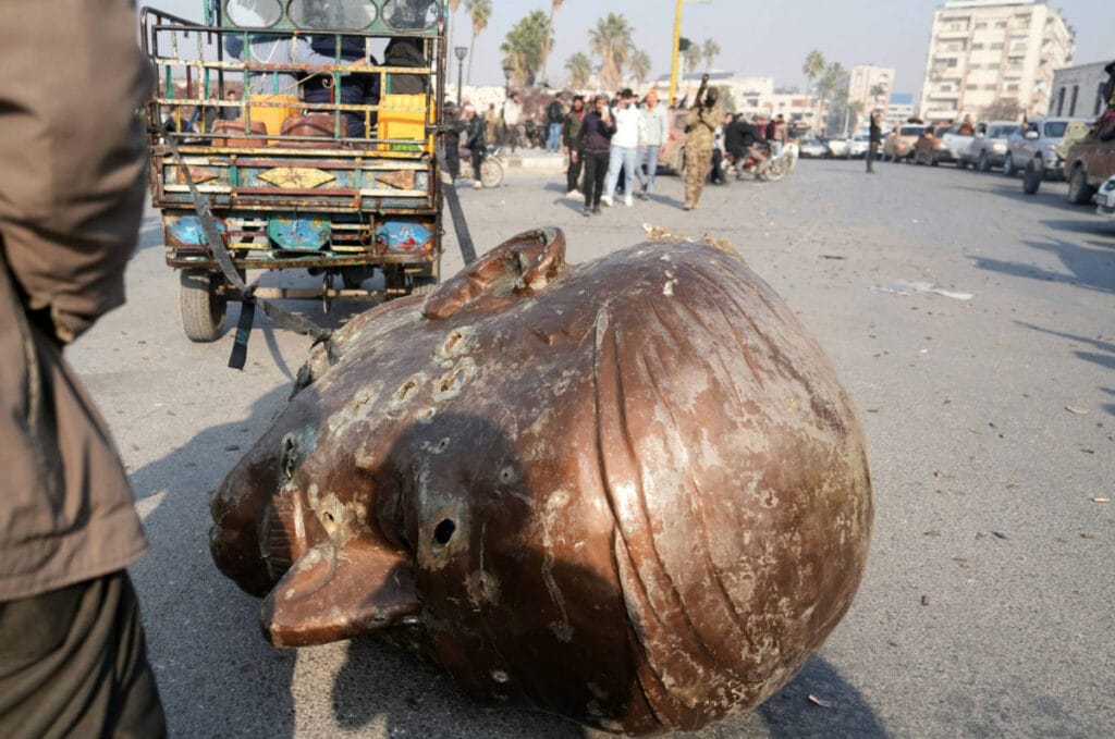 DIROBOHKAN: Nampak kepala pating Hafez A-Assat ayah Bashar Al-Assad dirobohkan kemudian ditarik oleh mobildi tengah kota. Foto: L'Orient Today