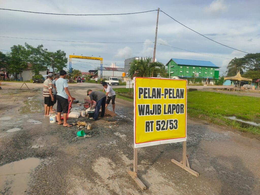 TAMBAL JALAN: Warga H.Thamrin RT 52 dan 53 berinisiatif melakukan penambalan badan jalan yang berlubang yang seringkali menjadi penyebab terjadinya kecelakaan lalu lintas.