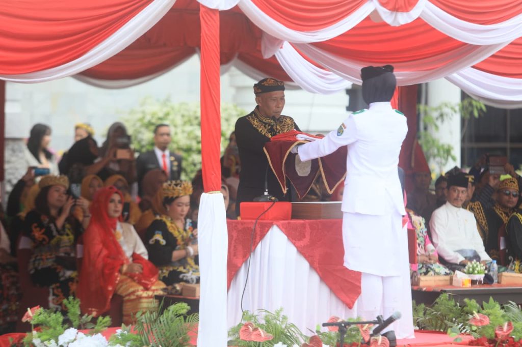 KHITMAD: Bupati Bulungan Syarwani, S.Pd.M.Si saat menyerahkan sang saka merah putih pada petugas pengibar bendera.