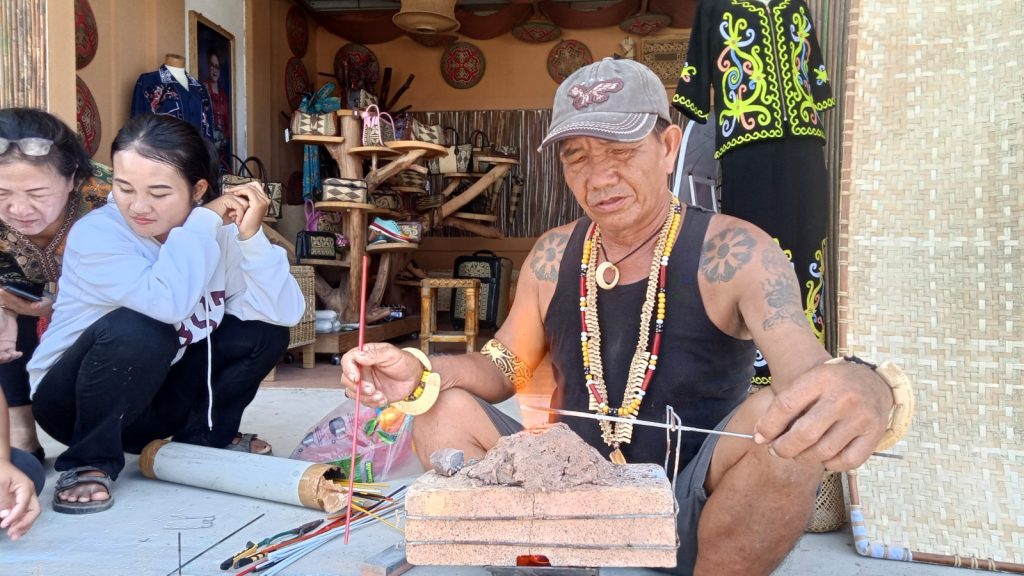Donles salah satu pengrajin manik tradisional Dayak Kabupaten Malinau saat menampilkan kepiawaianya dalam membuat manik dari lelehan kaca.