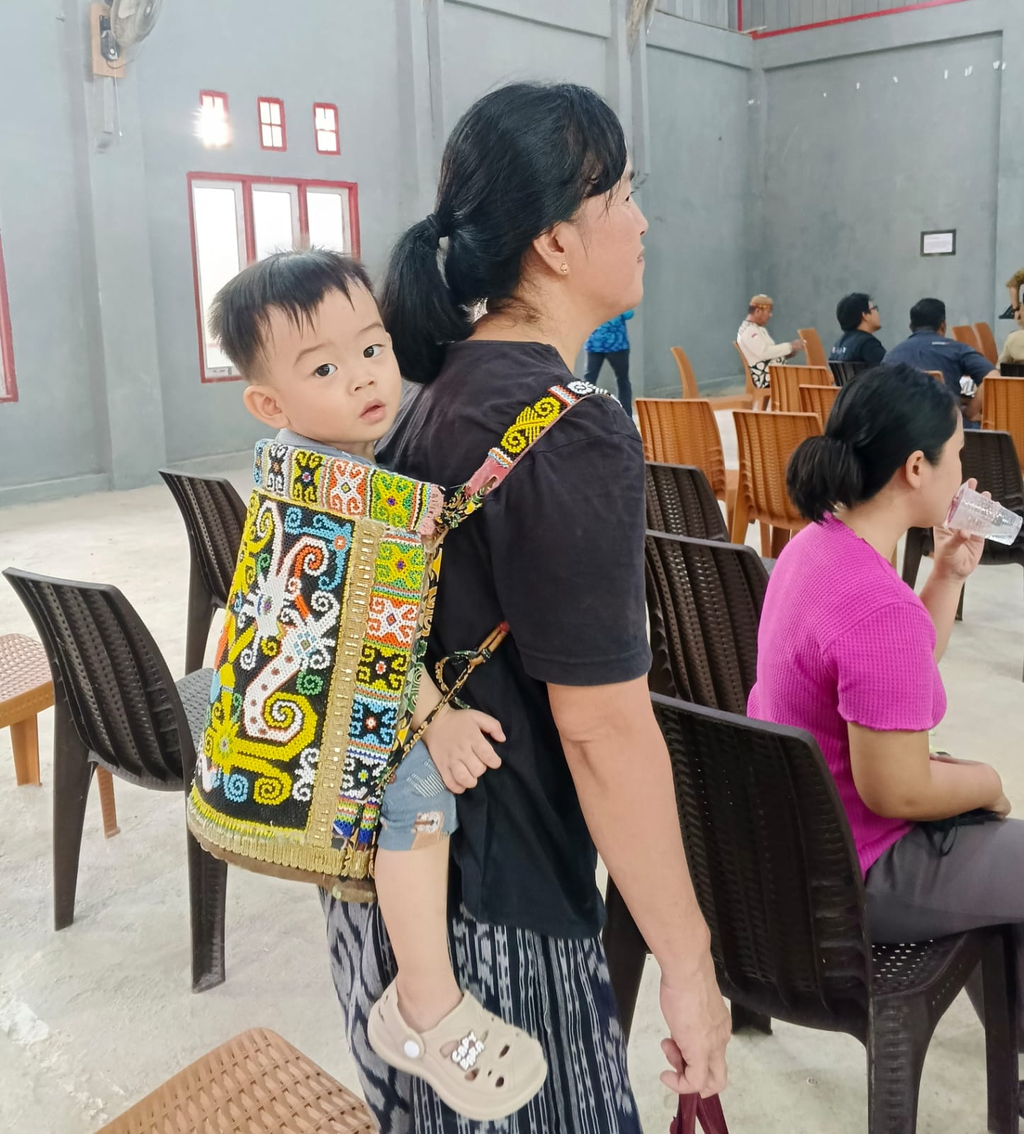 TRADISI: Seorang ibu masyarakat Dayak di Desa Long Lasan masih menggunakan alat gendong bayi tradisional warisan leluhur Bening Aban yang memiliki makna filosofis tinggi termasuk dipercaya menangkal pengarih roh jahat pengganggu anak bayi. (foto:Dedi Suhendra:Tanjungnews.com)